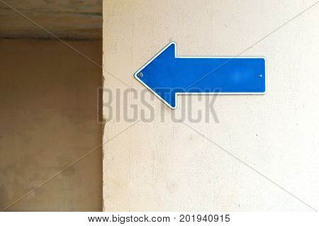 a pointer to the name of the street a sign on the wall of the building on the street