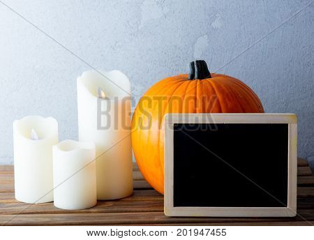 Fresh Autumn Pumpkin And Candles With Menu Blackboard