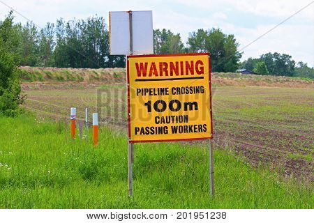 A warning pipeline crossing in 100m caution sign.