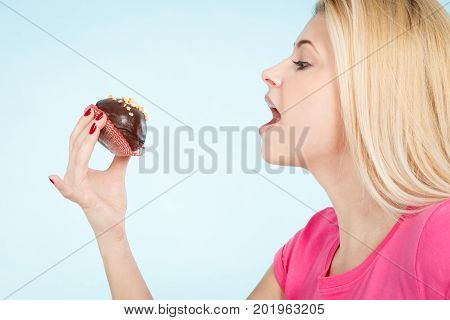 Woman Holding Chocolate Cupcake About To Bite