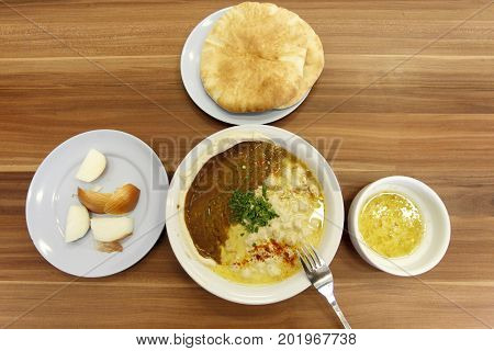 Hummus with pita bread and onion served in a restaurant in Tel Aviv, Israel.