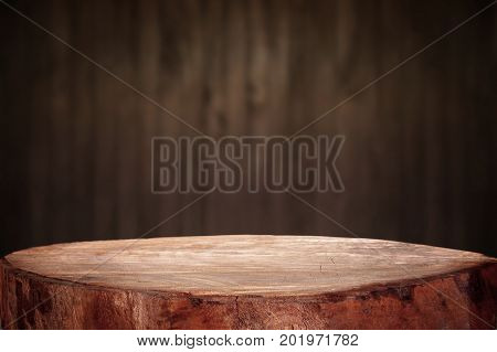 Old wood table with dark brown wall blurred background.