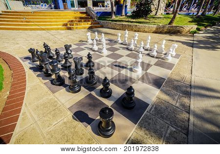 Cayo Coco island, Cuba, Iberostar Mojito resort, July 17, 2017, great amazing closeup view big wide chess board with it's figures lit by a sun rays in tropical garden near the swimming pool