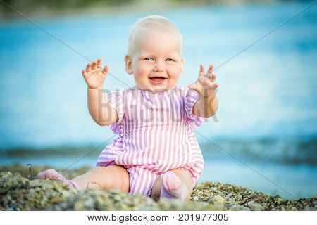 Happy little baby girl on the beach - summer vacation