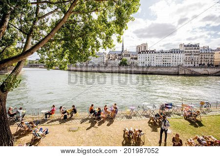 PARIS, FRANCE - August 07, 2017: People resting on the riverside cafe near the Arcole bridge in Paris