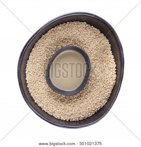 Tahini Sauce And Sesame Seeds In Black Bowls Isolated On White Background. Natural Paste Made From S