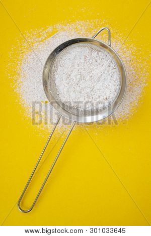 Sieve With Flour Heaped On Yellow Background. Creative Food Concept, Baking, Recipes, Pastry.