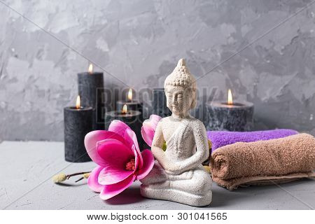 Black Burning Candles , Buddha And Pink Magnolia Flowers On Grey Textured Background. Spa Concept. S