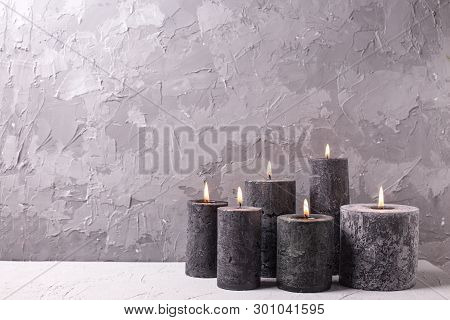 Black Burning Candles  On Grey Textured Background. Spa Or Still Life Concept. Selective Focus. Plac