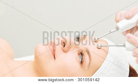 Microcurrent Esthetics Procedure. Beauty Girl Face. Cosmetology Machine. Doctor Hands. Two Micro Bal