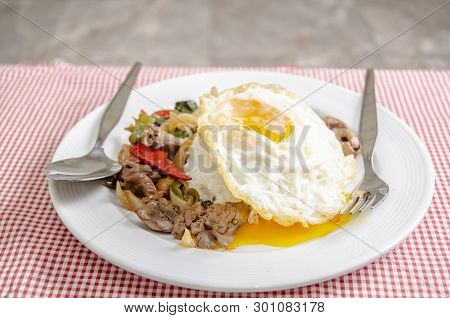 Fried rice with basil leaves and red cloth on the table.Ngredients of Basil Fried Chicken and fried 