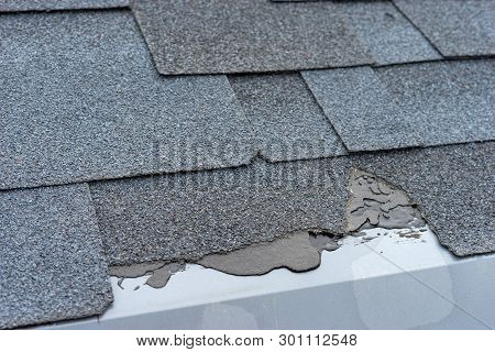 Сloseup View Of Asphalt Shingles Roof Damage That Needs Repair.