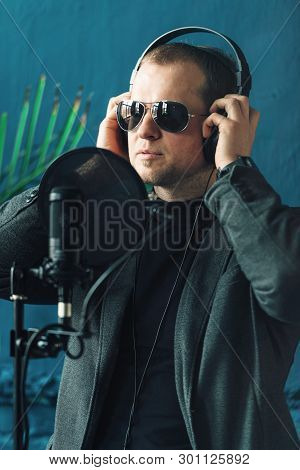 Close Up Of A Man Singer In A Headphones Recording A Song In A Home Studio