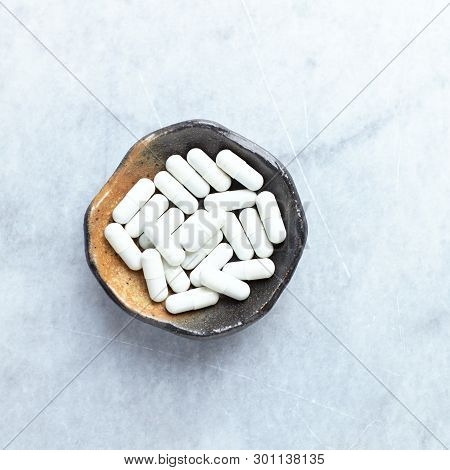 Tribulus Terrestris Extract. A Dietary Supplement. Bright Stone Background. Top View. Copy Space.