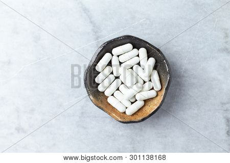 Tribulus Terrestris Extract. A Dietary Supplement. Bright Stone Background. Top View. Copy Space.