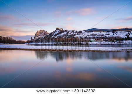 Snow Covered Devin Castle Ruins Above The Danube River In Bratislava, Slovakia At Sunrise