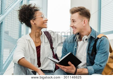 Two Multiethinc Students With Notebook Smiling In University