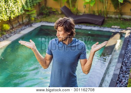 Man Chooses Chemicals For The Pool. Swimming Pool Service And Equipment With Chemical Cleaning Produ