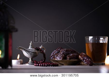 Ramadan Food And Drinks Concept. Ramadan Lantern With Arabian Lamp, Wood Rosary, Tea, Dates Fruit An