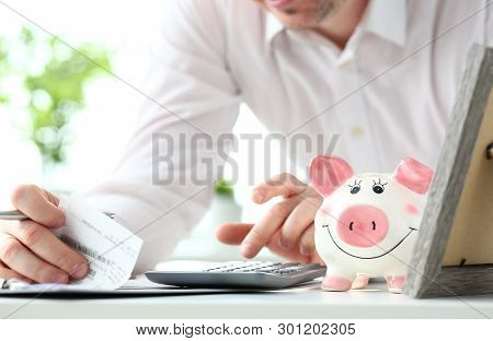 Funny Nice Piggybank And Male Business In Background Evaluating Expenses And Rechecking Financial Bi