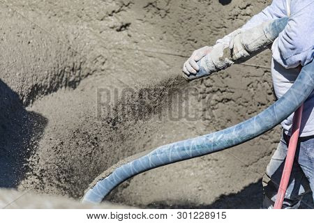 Pool Construction Worker Shooting Concrete, Shotcrete or Gunite Through Hose