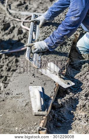 Pool Construction Worker Working With A Smoother Rod On Wet Concrete