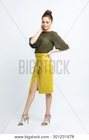 Model In Green Blouse, Yellow Suede Skirt With Yellow Belt, White Heeled Sandals Isolated On White B