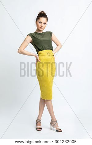 Model In Green Blouse, Yellow Suede Skirt With Yellow Belt, White Heeled Sandals Isolated On White B