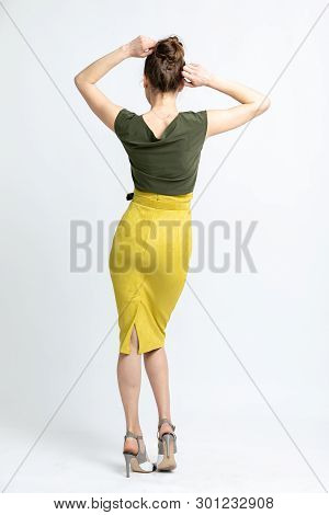 Model In Green Blouse, Yellow Suede Skirt With Yellow Belt, White Heeled Sandals Isolated On White B