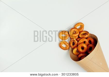 Drying Or Bagels Spilled Out Of A Paper Bag On A White Background, Plenty Of Space For Text. Bright 