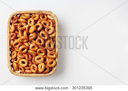 Bagels In A Wicker Bamboo Basket On A White Background, Place For Text. High Contrast, Top View.