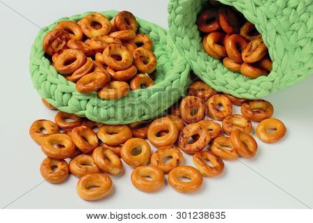 Drying Or Bagels In A Green Basket, Handmade, On A White Background. Bright Colors, High Contrast.