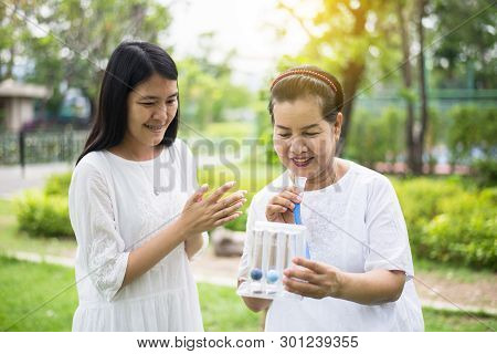 Elderly Asian Mother Using Incentive Spirometer Or Three Balls For Stimulate Lungs,encouragement Dau