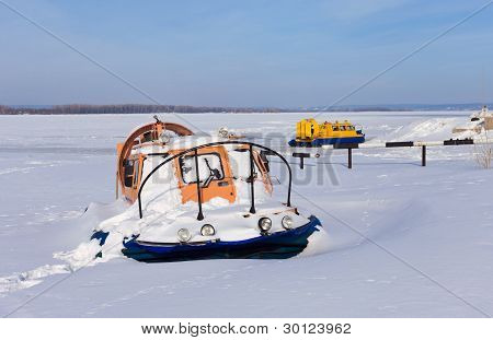 Hovercraft sulla riva di un fiume ghiacciato