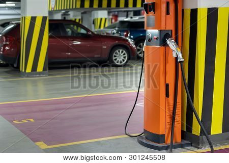 Electric Car Fast Charging Station At Indoor Underground Parking. Power Supply Point Network For Hyb