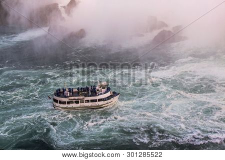 View Of Tourist Boat On Rumbling Waves Of Niagara Falls. Beautiful Backgrounds. Tourism Concept.
