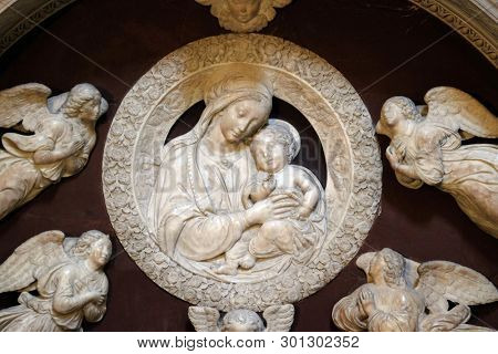 FLORENCE, ITALY - JANUARY 10, 2019: Madonna with four angels, Tomb of Filippo Strozzi, marble, by Benedetto da Majano, Santa Maria Novella Principal Dominican church in Florence, Italy