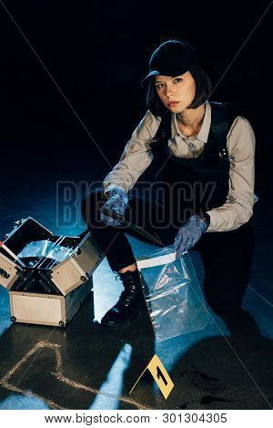 Investigator Holding Knife And Ziploc Bag At Crime Scene