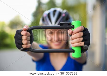 Girl with bicycle  lock. Bicycle U- lock