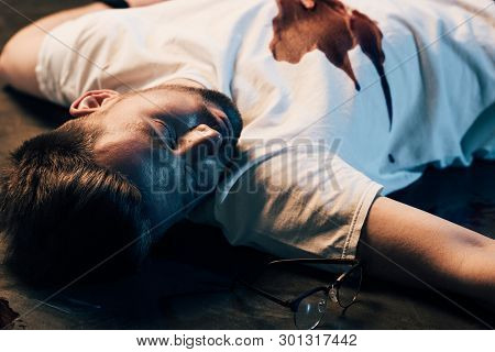 Dead Man With Blood On T-shirt On Floor At Crime Scene