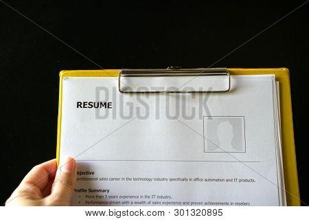 Resume On A Clipboard With Office Table Background. A Hiring Or Employment Concept