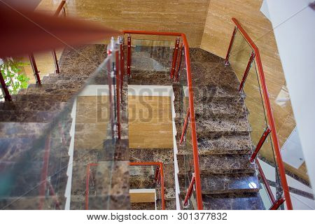 The Top View On Multystoried Ladder Flight. A Modern Marble Ladder In Office Building.