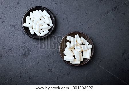 Glutamine And Bcaa Amino Acids. Nutrition For Bodybuilding. Fitness Supplements On Black Stone Backg
