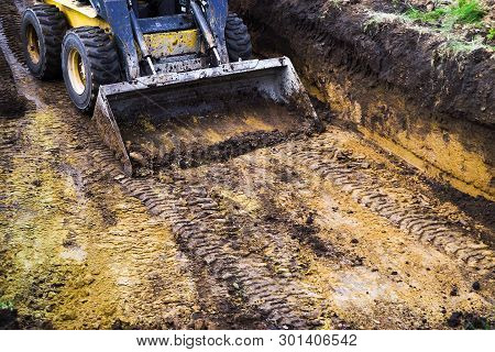 Partial View Of Mini Loader In Mud Standing In Pit During Excavation Works