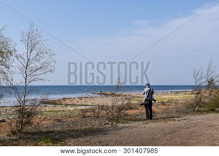 Male Photographer Standing By The Coast Of The Baltic Sea At The Swedish Island Oland