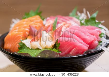 Mixed Sliced Fish Sashimi On Ice In Black Bowl. Sashimi Salmon Tuna Hamachi Prawn And Surf Calm Set,