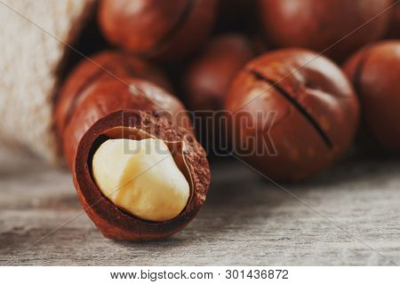 Macadamia Nut On A Wooden Table In A Bag, Closeup, Top View