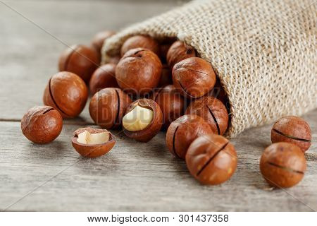 Macadamia Nut On A Wooden Table In A Bag, Closeup, Top View