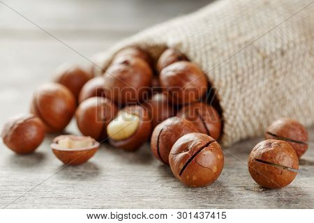 Macadamia Nut On A Wooden Table In A Bag, Closeup, Top View