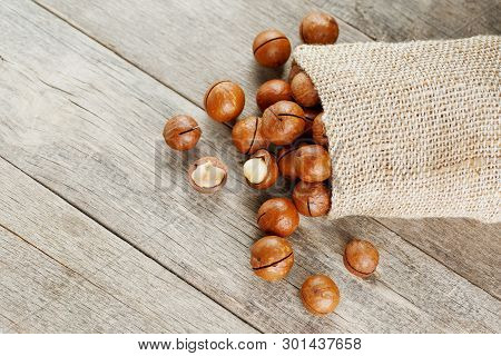 Macadamia Nut On A Wooden Table In A Bag, Closeup, Top View